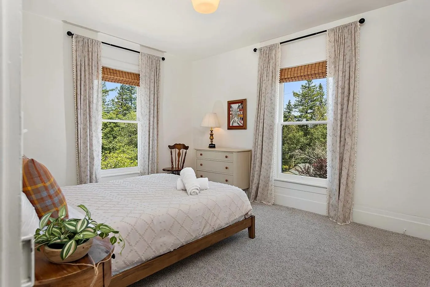 Queen bedroom with two tall windows onto the trees
